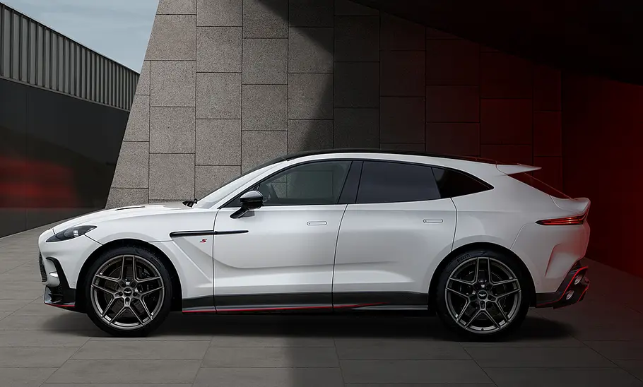 Der Aston Martin DBX S in der Seitenansicht vor einem modernen Gebäude.