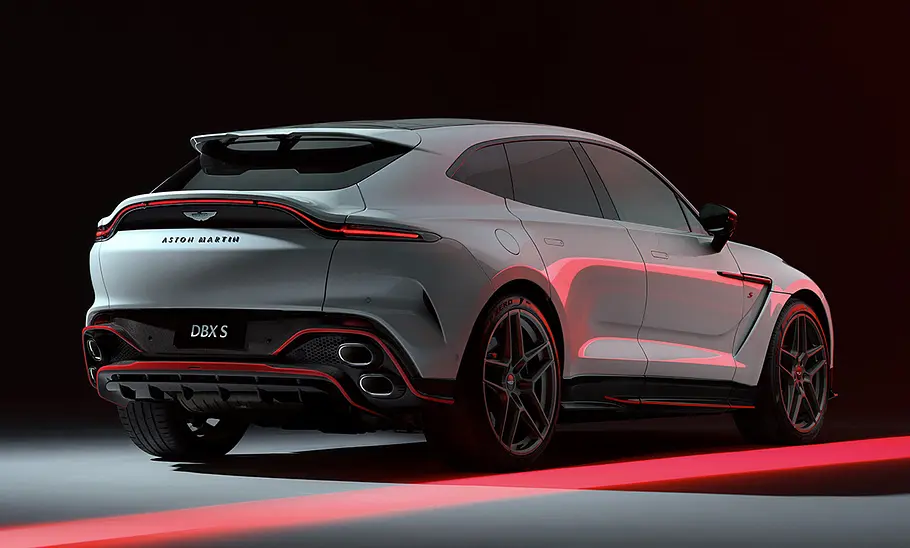 Der Aston Martin DBX S stehend von schräg hinten. Der Hintergrund ist dunkel.