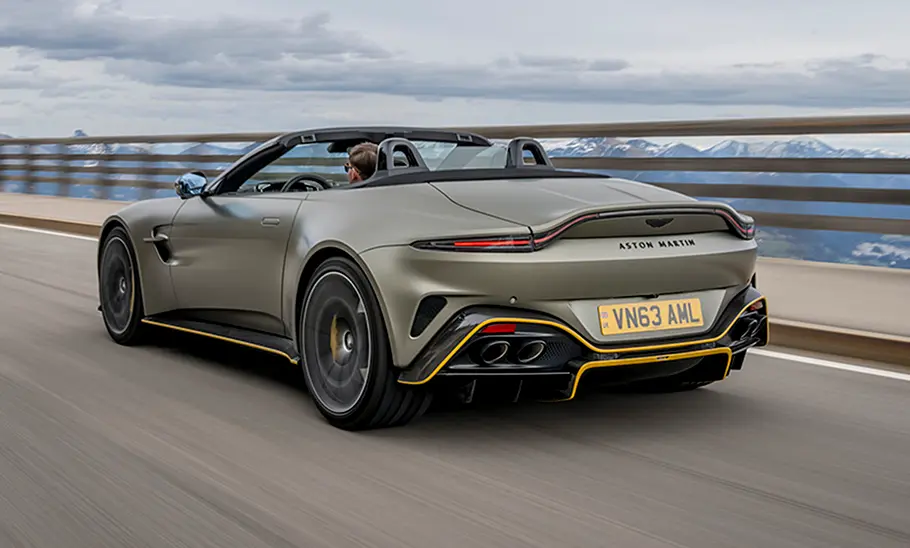 Der Aston Martin Vantage Roadster (2025) fahren auf einer Straße, schräg von hinten abgelichtet.