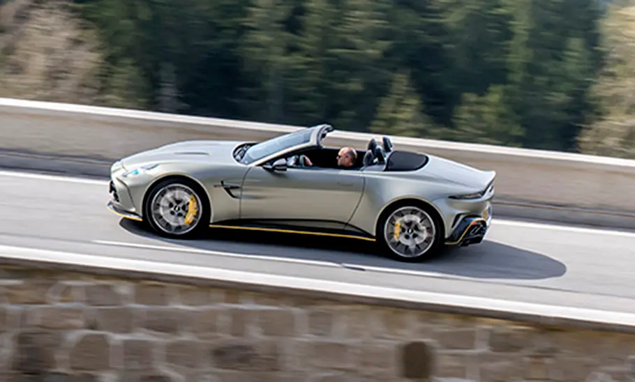 Der fahrende Aston Martin Vantage Roadster (2025) in seitlicher Ansicht mit offenem Verdeck.