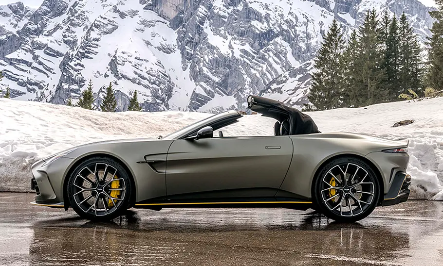 Der Aston Martin Vantage Roadster (2025) stehend auf einer Straße in der Seitenansicht, das Verdeck öffnet sich gerade.