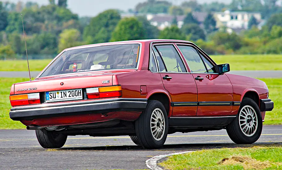 Audi 200 5E fahrend von schräg hinten fotografiert.