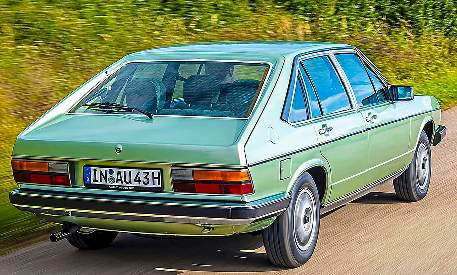 Der Audi 100 Avant fahrend von schräg hinten fotografiert.
