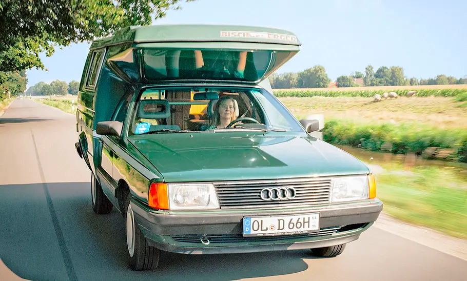 Der Audi 100 Bischofberger Family fahrend von schräg vorne fotografiert.