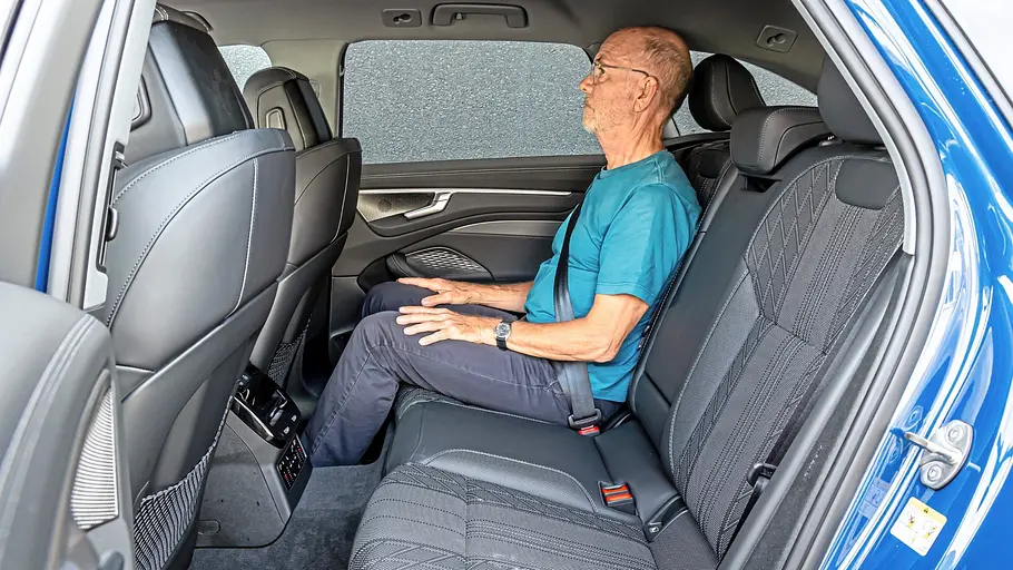 Ein Mann sitzt im Fond des Audi A6 Avant, sein Kopf reicht nah an den Dachhimmel
