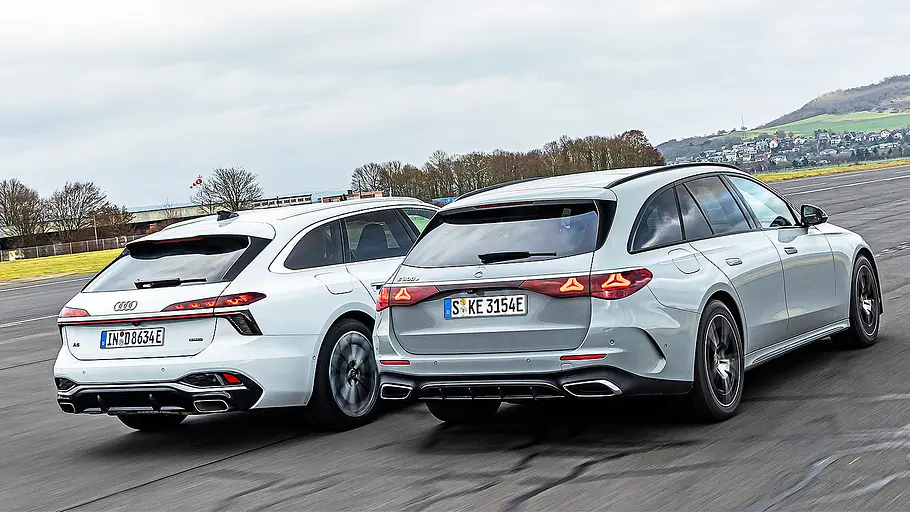 Blick von schräg hinten auf die beiden fahrenden Kombis Audi A6 Avant und Mercedes E-Klasse T-Modell.