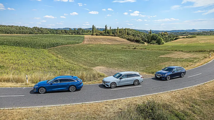 Audi A6 Avant, Mercedes E 450 d 4Matic T-Modell und BMW 540d xDrive Touring von oben auf einer kurvigen Landstraße