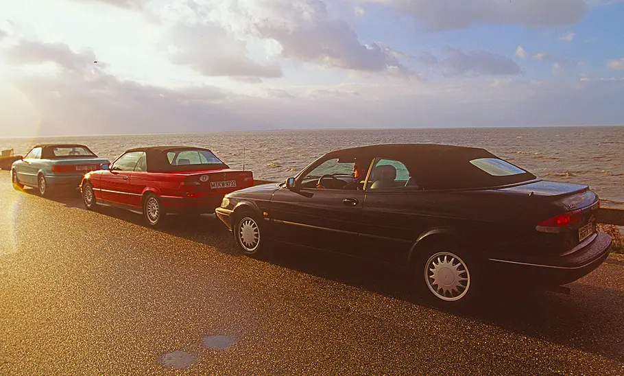 Audi Cabrio/BMW 320i Cabrio/Saab 900 Cabrio Audi Cabrio, BMW 320i Cabrio und Saab 900 Cabrio stehend von schräg hinten.