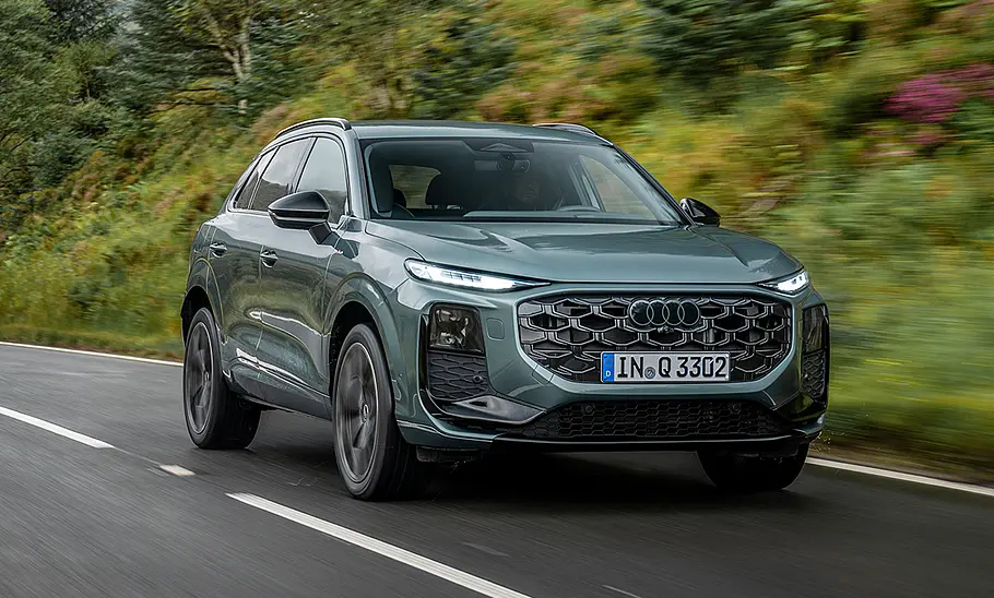 Der Audi Q3 (2025) fahrend auf einer Straße in der Ansicht von schräg vorne.