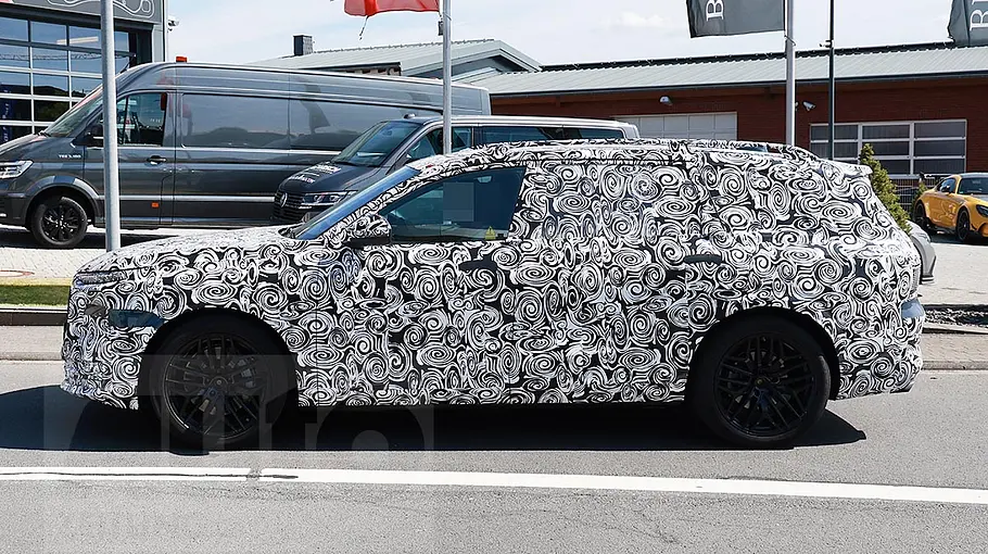 Audi Q9 (2026) Der Audi Q9 (2026) als Erlkönig fahrend von der Seite fotografiert.