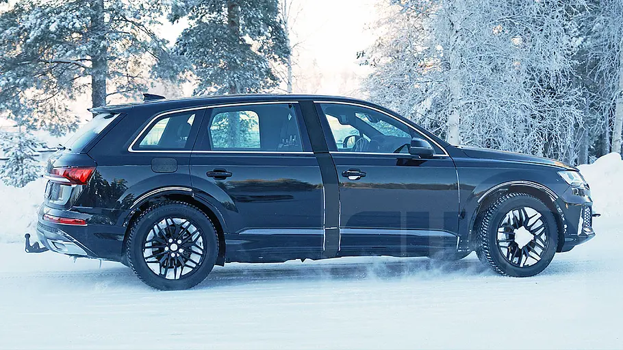 Audi Q9 (2026) Blick von der Seite auf das fahrende Mule des Audi Q9 (2026).