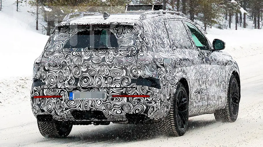 Audi Q9 (2026) Blick von schräg hinten auf den fahrenden Erlkönig des Audi SQ9 (2026).