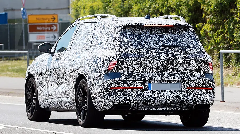 Audi Q9 (2026) Der Audi Q9 (2026) als Erlkönig fahrend von schräg hinten fotografiert.
