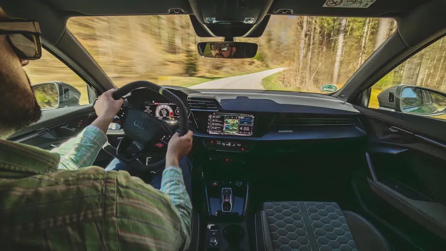 Das Cockpit des Audi RS 3 Competition Limited während der Fahrt über die Schulter des Fahrers fotografiert.