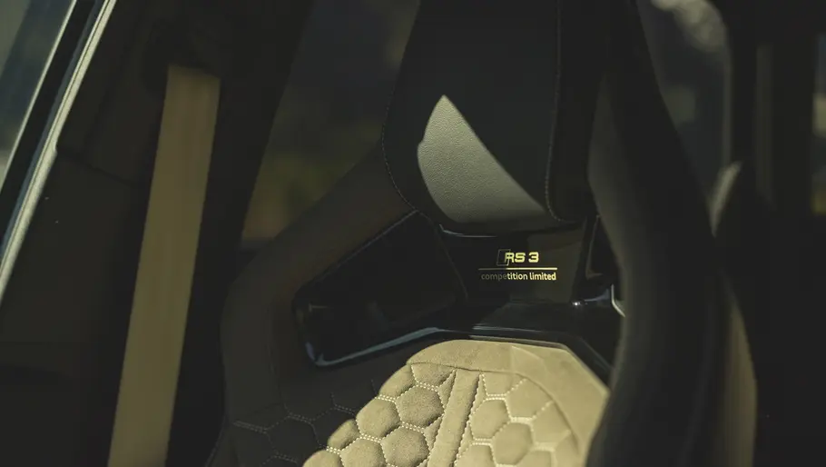 Die Zierleiste zwischen Rückenlehne und Kopfstütze des Beifahrersitzes im Audi RS 3 Competition Limited im Detail.