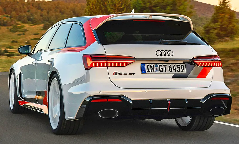Der Audi RS 6 Avant GT (2024) fährt über eine Landstraße, von schräg hinten fotografiert.