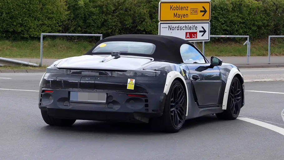 Der Audi TT-Nachfolger fährt als Prototyp durch einen Kreisverkehr, von hinten rechts fotografiert.