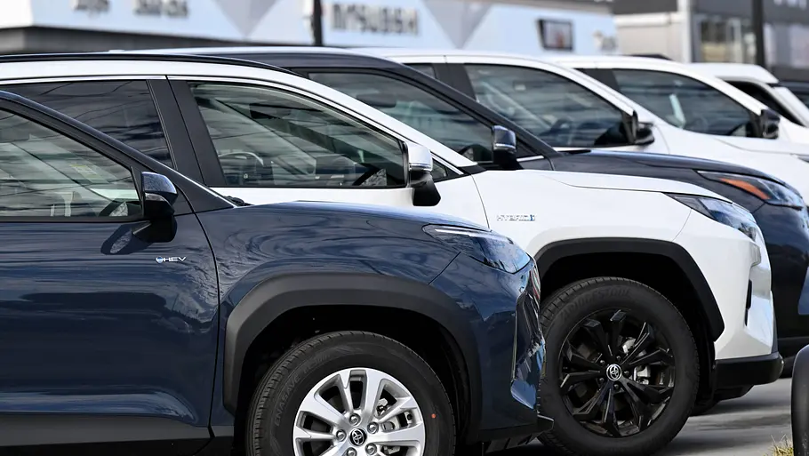 Auto kaufen, leasen oder abonnieren Mehrere Neuwagen von Toyota stehen in einer Reihe auf einem Händlerhof zum Verkauf ausgestellt.