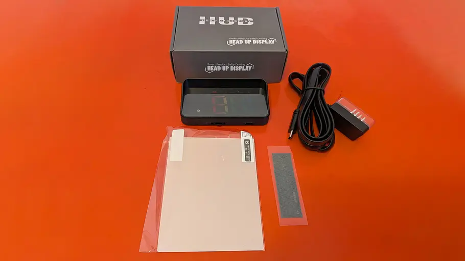 Das Bild zeigt den Lieferumfang des AutoGadgets24 HUD OBD2, einem Head-up-Display zum Nachrüsten.