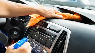 Das Armaturenbrett eines Autos wird mit einem Mikrofasertuch abgewischt. - Foto: iStock/AndreyPopov Das Armaturenbrett eines Autos wird mit einem Mikrofasertuch abgewischt. - Foto: iStock/AndreyPopov
