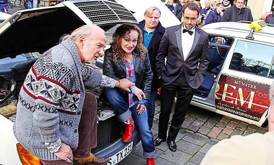 Mercedes W124 Taxi Vier Schauspieler sitzen auf der Front des Mercedes W124 Taxi.