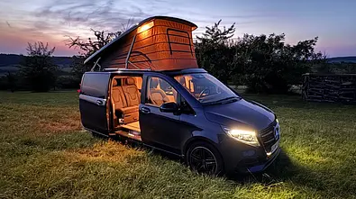 Der Mercedes V-Klasse Marco Polo mit aufgestelltem Dach und geöffneten Schiebetüren im freien Feld. - Foto: Johannes Riegsinger