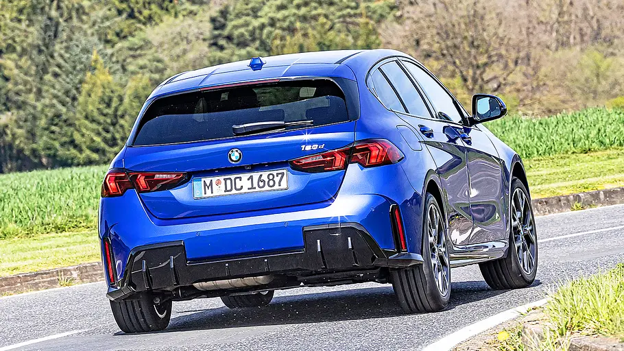 BMW 1er Blick von schräg hinten auf den fahrenden BMW 1er.