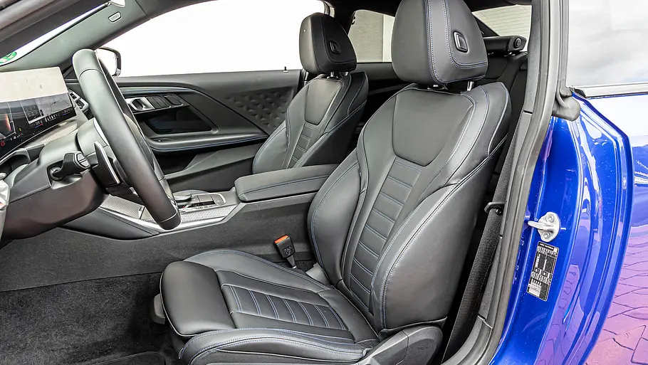BMW 2er Coupé gegen Honda Prelude im Vergleichstest Der Innenraum des BMW 220i M Sport Coupé zeigt schwarze Ledersitze mit blauen Nähten, Lenkrad, Display und Mittelkonsole.