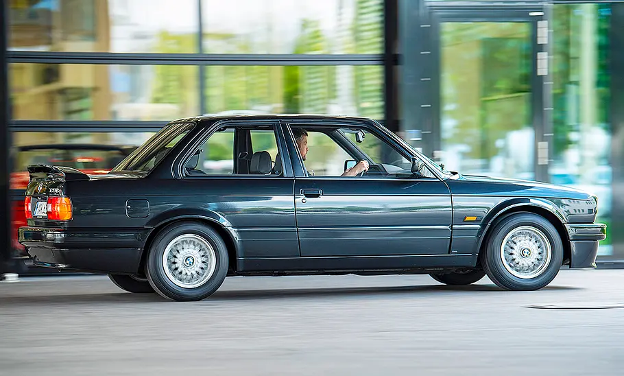 Der BMW 320is fahrend von der Seite fotografiert.
