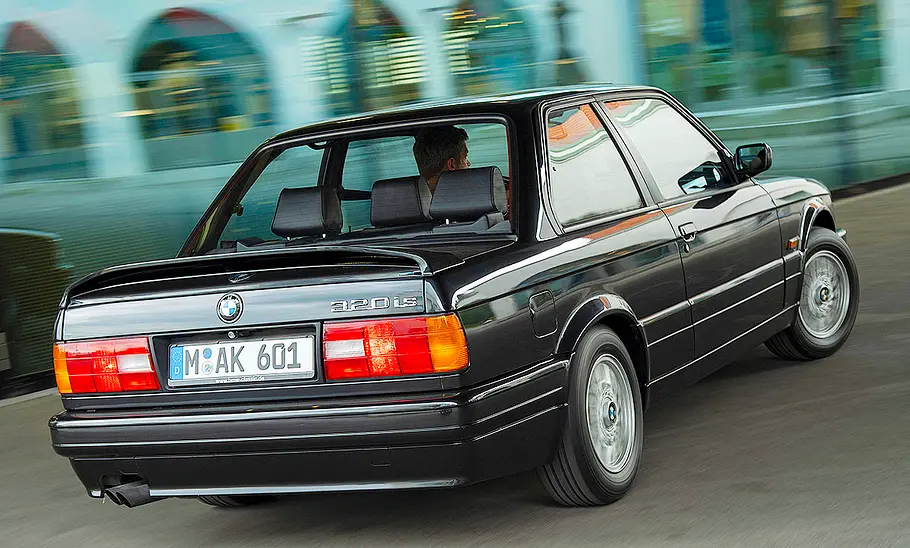 Der BMW 320is fahrend von schräg hinten fotografiert.