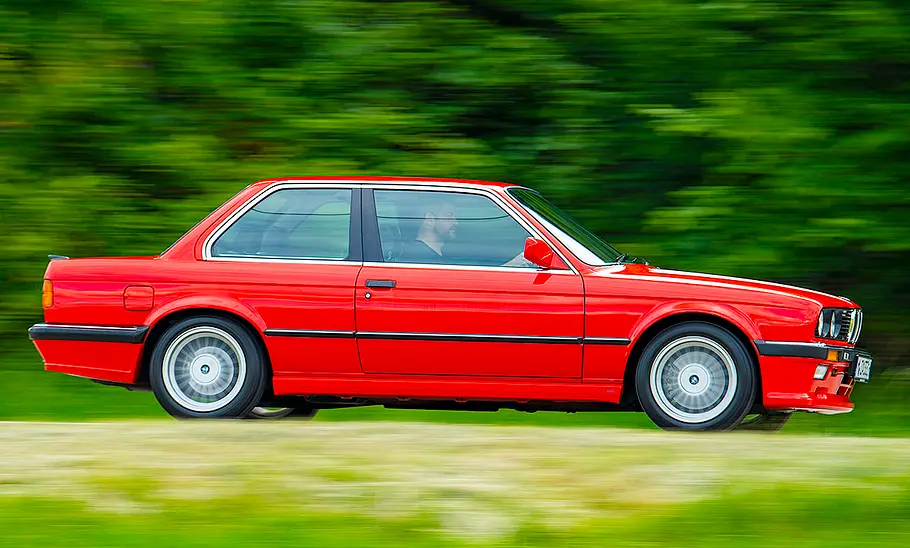 Der BMW 333i fahrend von der Seite fotografiert.