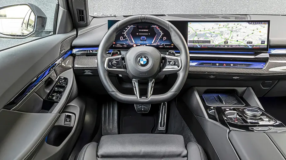 Cockpit des BMW 540d xDrive Touring mit gebogenem Curved Display und blauer Ambientebeleuchtung