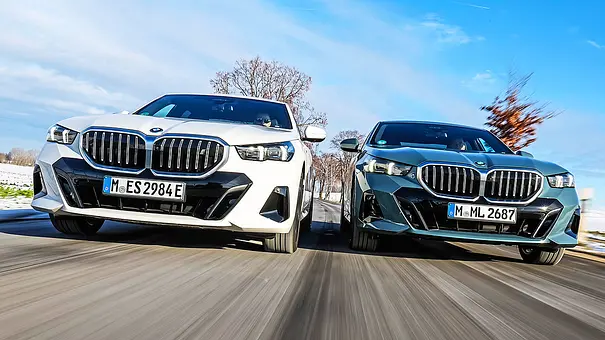 Blick von vorne auf die fahrenden BMW i5 eDrive40 und BMW 540d xDrive. - Foto: Daniela Loof
