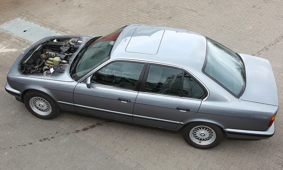BMW E34 Der BMW E34 schräg von oben mit geöffneter Motorhaube.