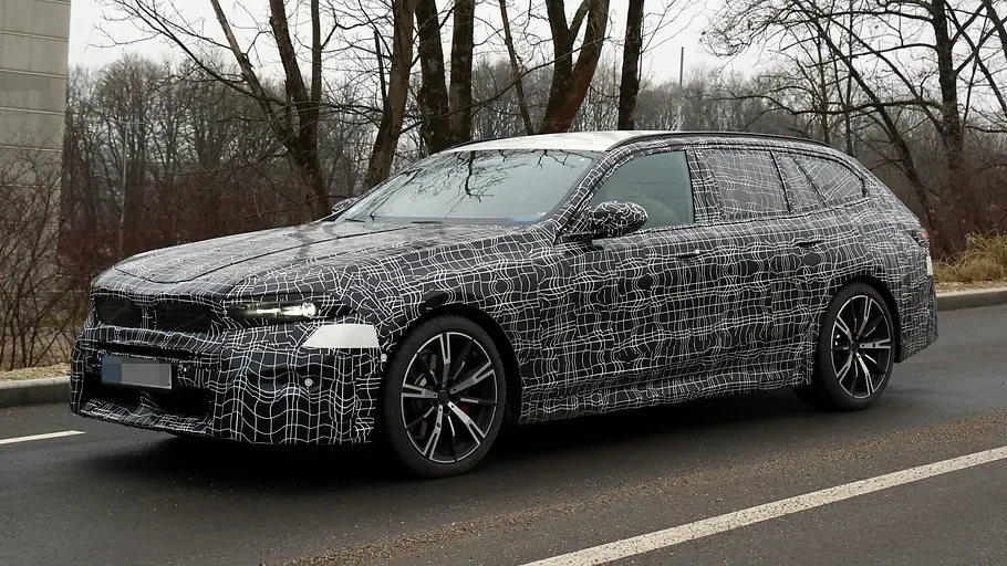 Das BMW 5er Touring Facelift als getarnter Prototyp von schräg vorne fotografiert.