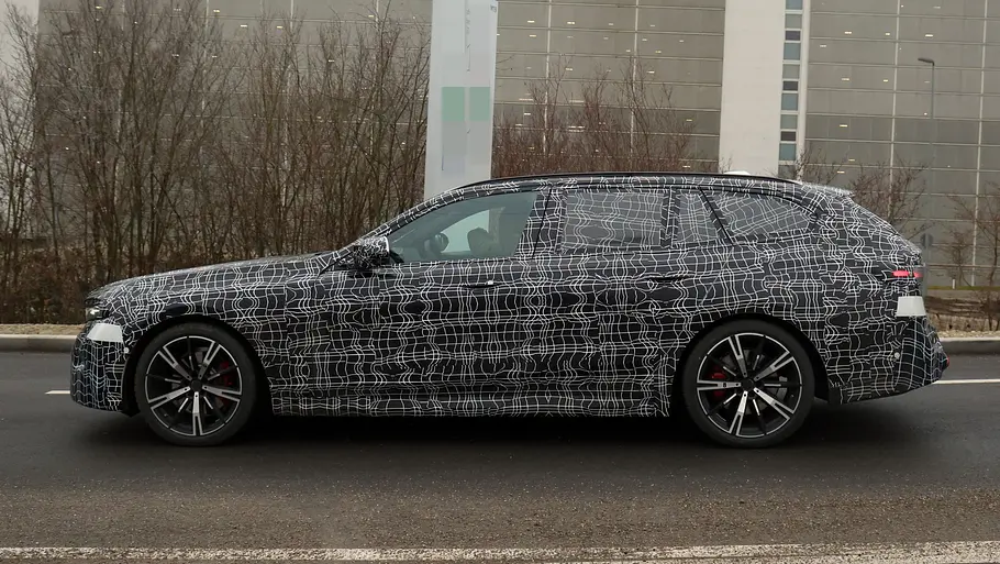 Das BMW 5er Touring Facelift als getarnter Prototyp von der Seite fotografiert.