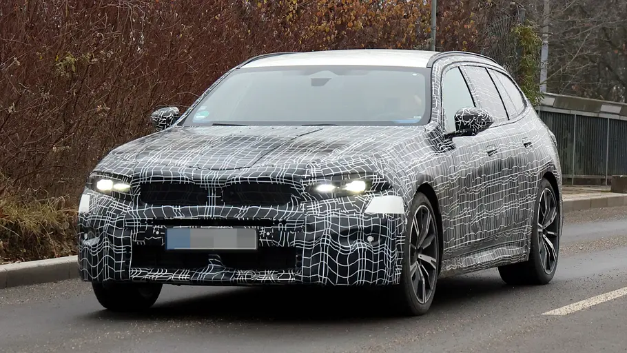 Das BMW 5er Touring Facelift als getarnter Prototyp von schräg vorne fotografiert.