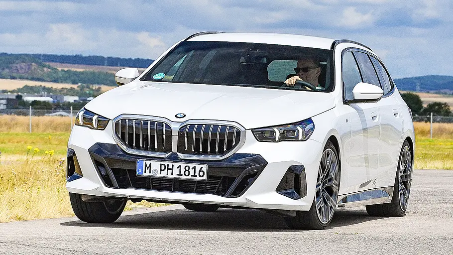 BMW 5er Touring Blick von schräg vorne auf den fahrenden BMW 5er Touring.