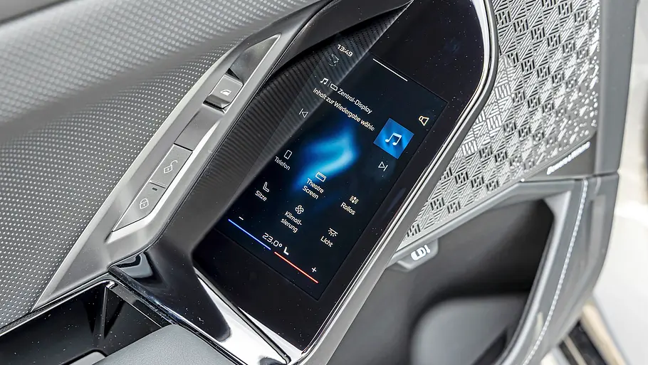 BMW 740 xDrive Einzeltest 7er Facelift In der Autotür des BMW 7er sind ein Touchscreen, Tasten und ein gemustertes Lautsprechergitter in silber-schwarze Verkleidung eingelassen.