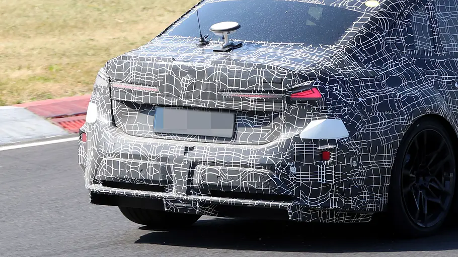 BMW i3 M (2027) Der BMW i3 M fährt als Erlkönig auf einer Rennstrecke, das Heck im Detail fotografiert.
