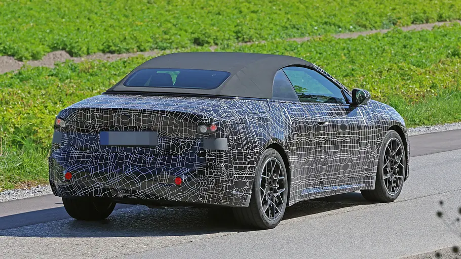 Der Erlkönig des BMW i4 Cabrio fahrend von schräg hinten rechts.