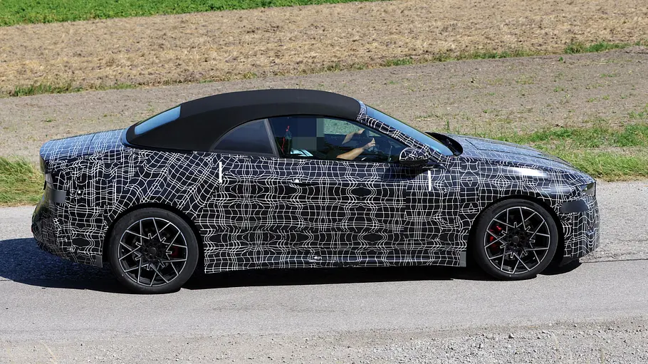Der Erlkönig des BMW i4 Cabrio fahrend von der Seite rechts.