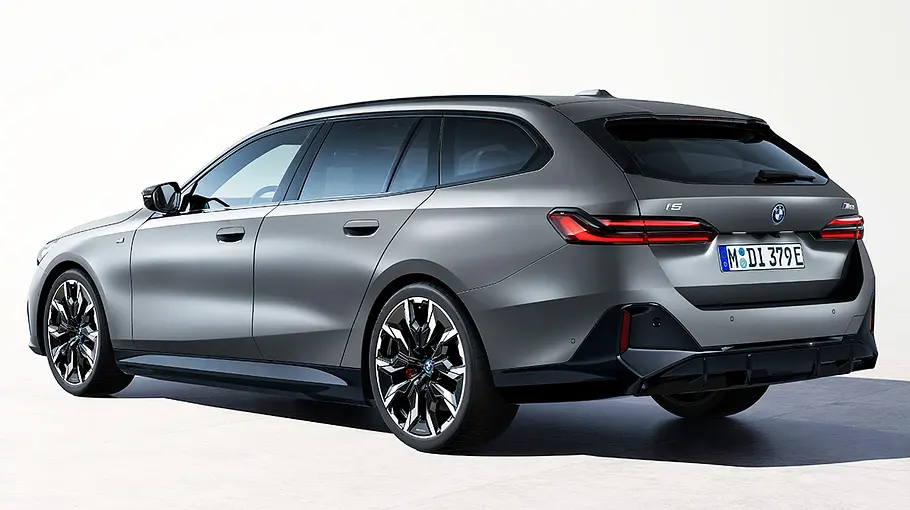 Der BMW i5 Touring stehend, von schräg hinten links.