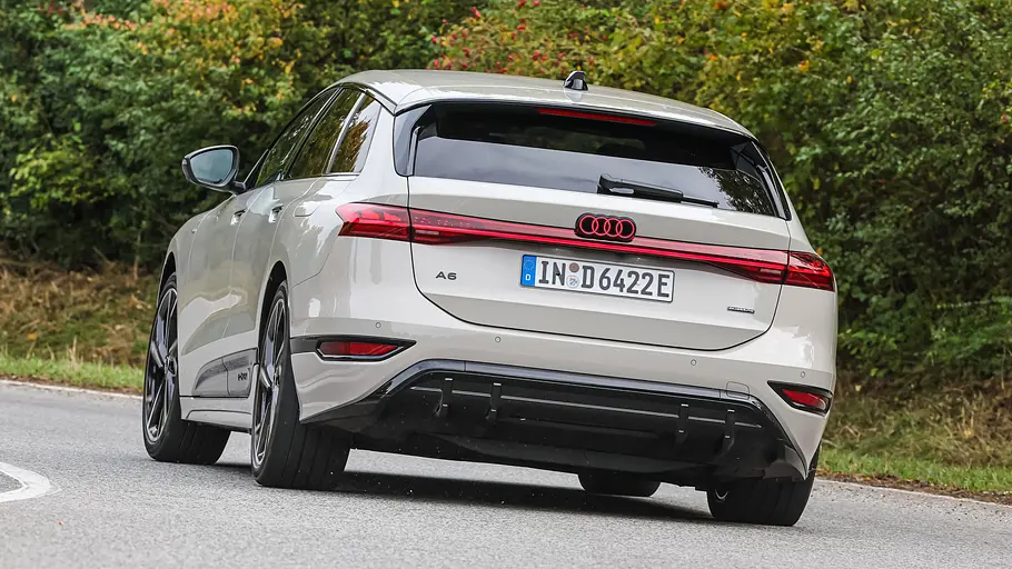 Audi A6 Avant e-tron Der Audi A6 Avant e-tron fährt durch eine Linkskurve, von hinten fotografiert.