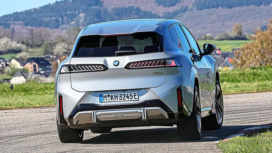 BMW iX3 Blick von hinten auf den fahrenden BMW iX3.