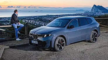 AUTO ZEITUNG-Redakteur Michael Godde am BMW iX3 vor Stadt- und Meerkulisse im Abendrot. - Foto: BMW AUTO ZEITUNG-Redakteur Michael Godde am BMW iX3 vor Stadt- und Meerkulisse im Abendrot. - Foto: BMW