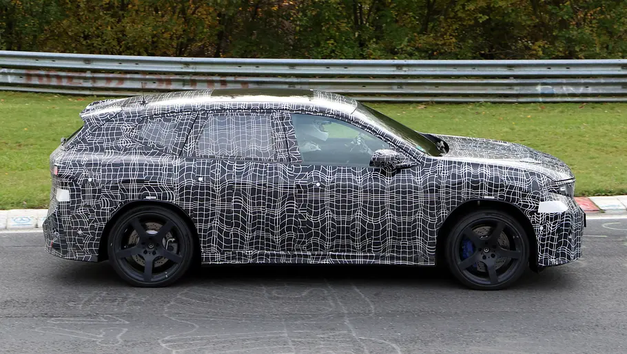 BMW iX3 M (2027) Der BMW iX3 (2027) fährt als Erlkönig auf der Nürburgring-Nordschleife, von rechts fotografiert.