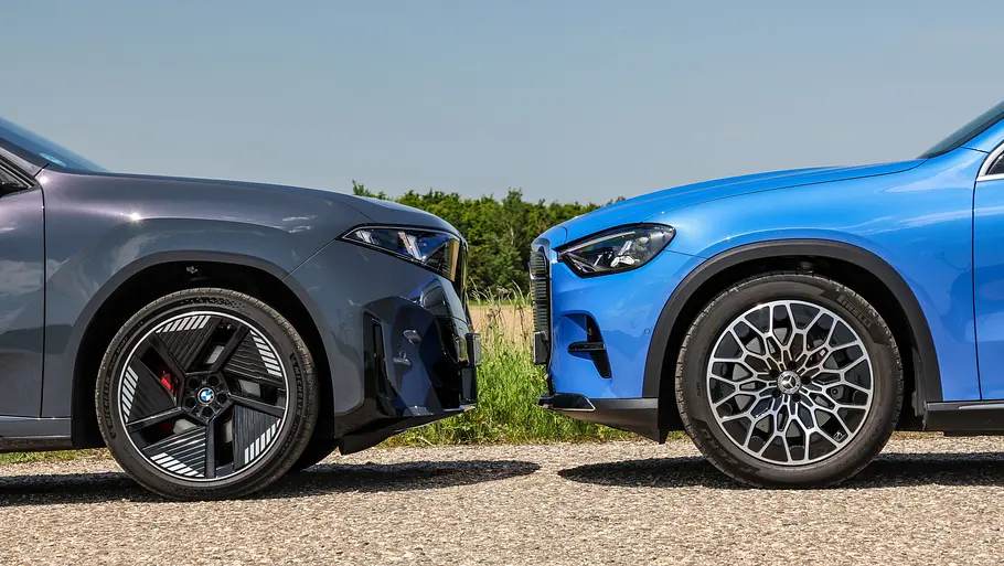 BMW iX3/Mercedes GLC EQ Eine Detailaufnahme zeigt BMW iX3 und Mercedes GLC EQ, die sich gegenüberstehen.
