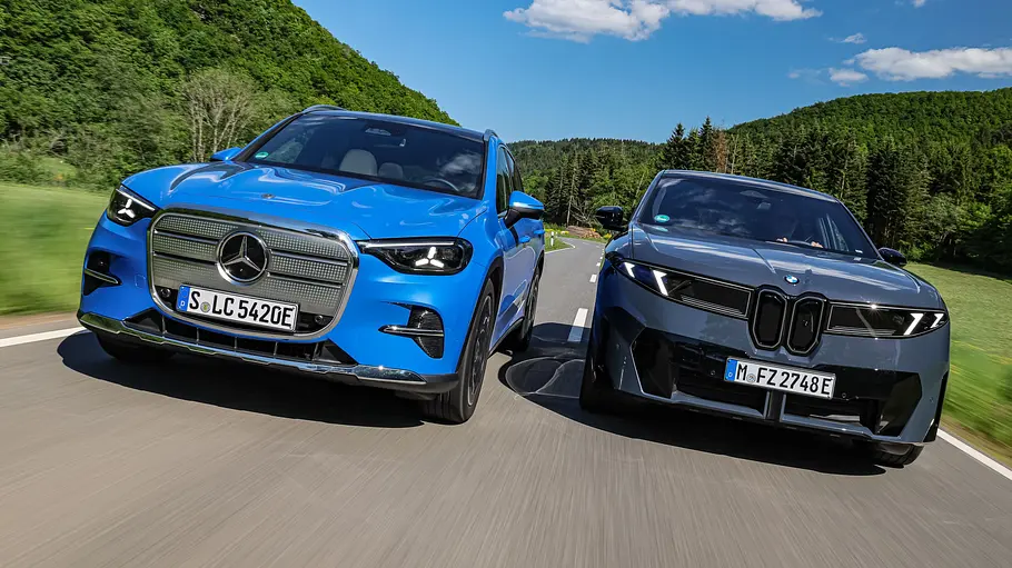 Mercedes GLC EQ/BMW iX3 Mercedes GLC EQ und BMW iX3 fahren nebeneinander, von vorne fotografiert.