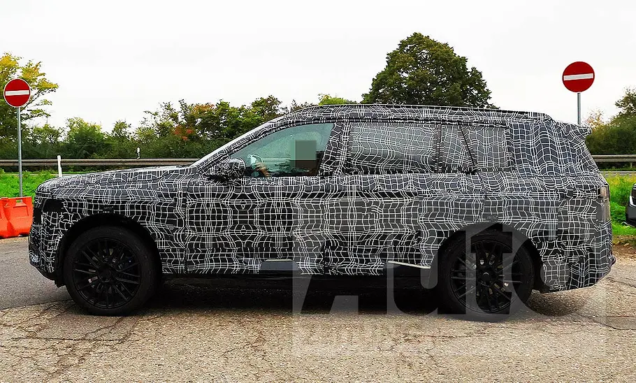 BMW iX7 (2027) Blick von der Seite auf den fahrenden BMW iX7 (2027).